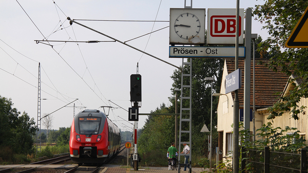 Regionalbahn am Bahnhalt Prösen Ost, rechts im Bild eine Uhr und ein altmodisches Bahnhofsschild, Foto: Michael Jungclaus, MdL